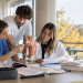 Tre laureati delle professioni sanitarie studiano insieme in un’aula universitaria