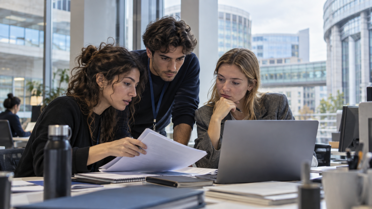 Tre giovani tirocinanti collaborano in un ufficio durante un’esperienza di formazione nelle istituzioni europee