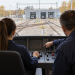 Formazione per macchinisti Trenitalia: scena illustrativa con una giovane e un istruttore nella cabina di un treno.
