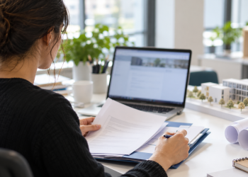 Giovane candidata prepara documenti e domanda online per una selezione di lavoro.