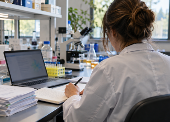 Giovane ricercatrice prepara un progetto al computer in un laboratorio universitario