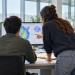 Due giovani ricercatori di spalle collaborano al computer, immagine illustrativa per i tirocini JRC 2027.
