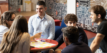 Partecipanti al progetto iliadship riuniti attorno a un tavolo durante un’attività di gruppo con fogli, penne e post-it.