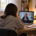 Studentessa ripresa di spalle davanti a un computer durante un colloquio psicologico online.